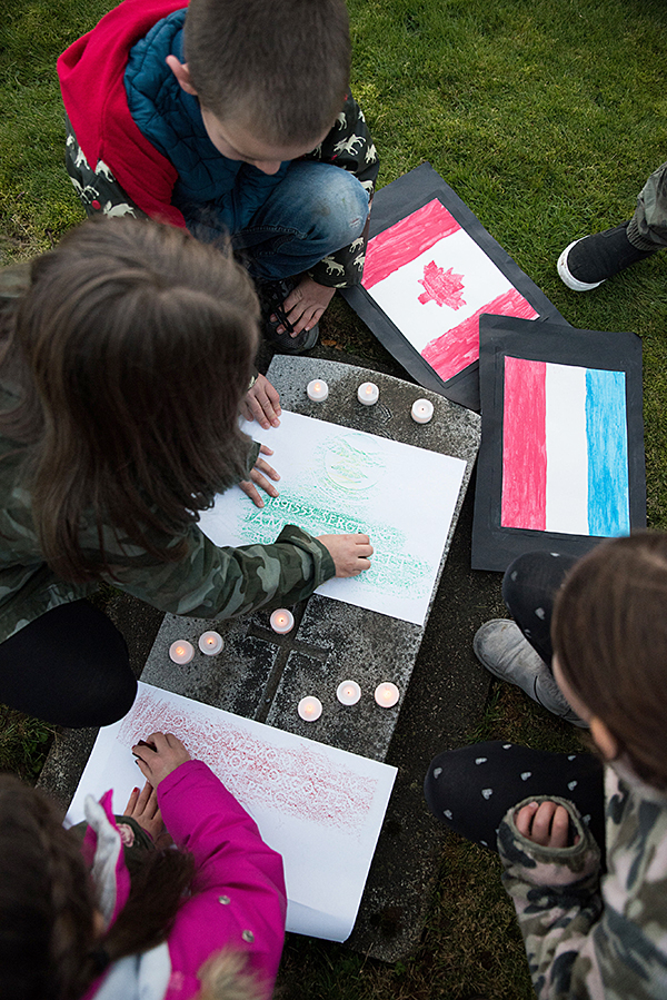 Students imprinting the name of a Canadian soldier by rubbing crayons over a pice of parchment. Ashley Martens photo.