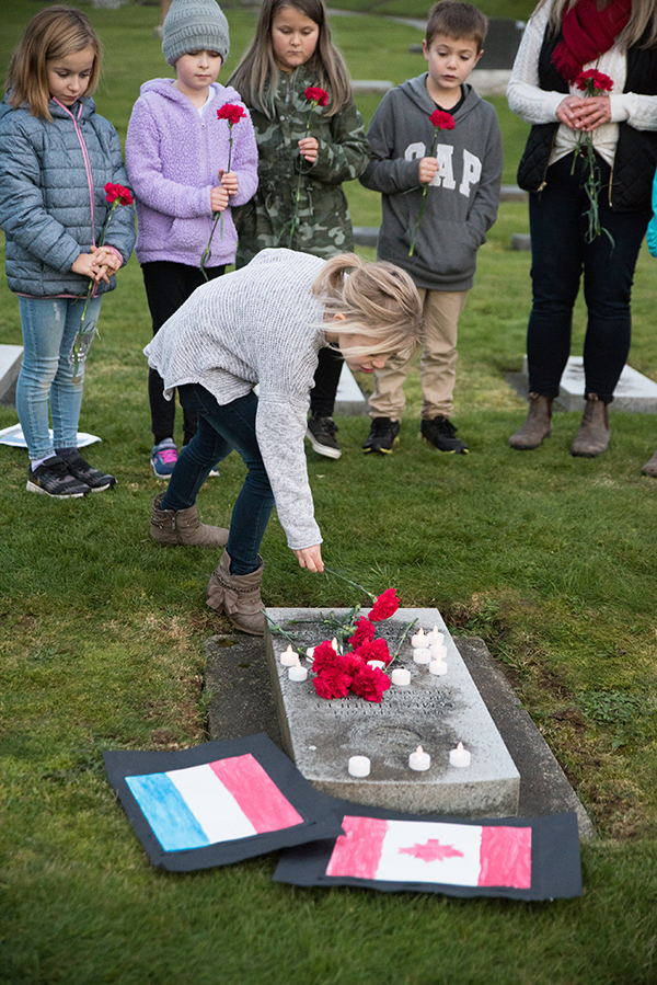 A student laying a tulip at the grave on one Abbotsford soldier killed in the Second World War. Ashley Martens photo.