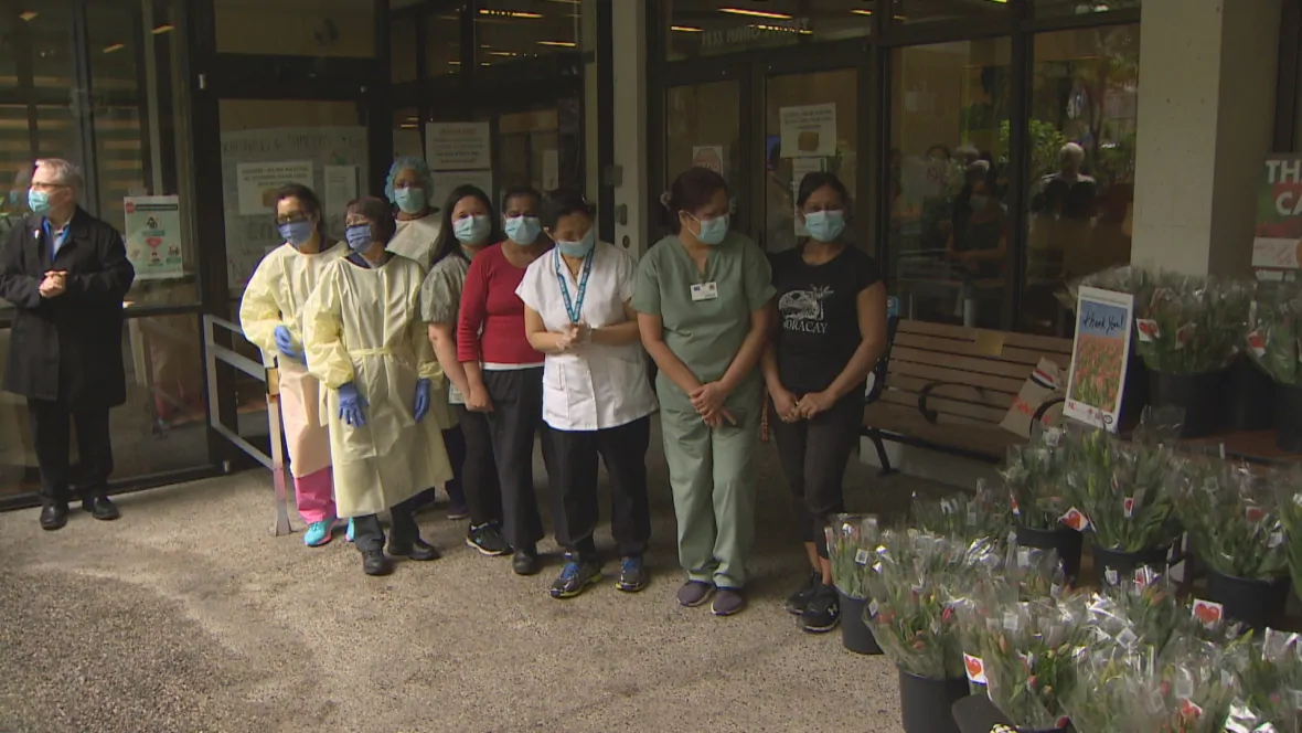 Frontline workers from the Haro Park Centre, a long-term care home in Vancouver, line up to receive their tulip bouquets. (CBC)